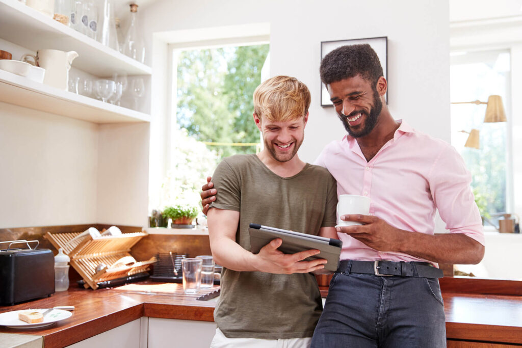 Young couple in kitchen deciding between a basic vs enhanced title insurance policy 