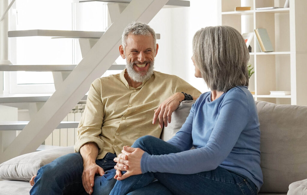Older couple sitting on couch discussing title insurance from Quaint Oak Abstract