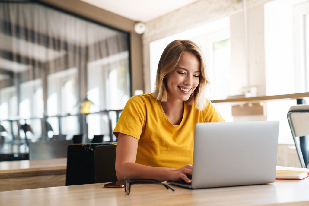 Young woman using remote online notarization from Quaint Oak Abstract on laptop in a open-desk setting